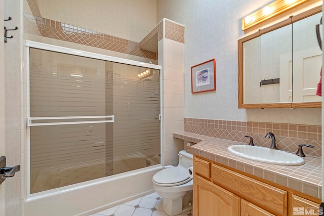 full bathroom with vanity, combined bath / shower with glass door, and toilet