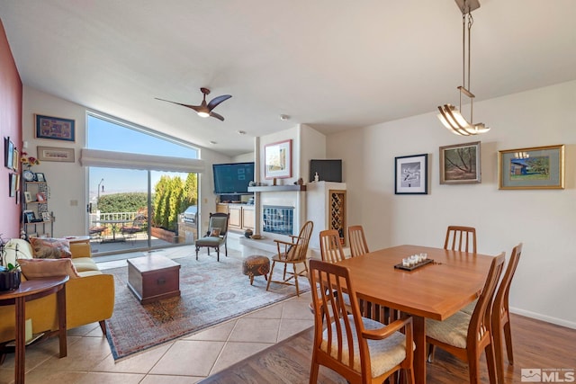 tiled dining area with vaulted ceiling and ceiling fan