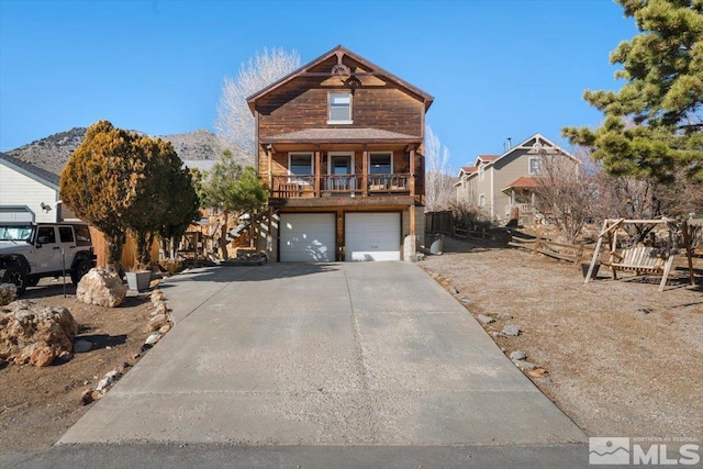 view of front of house featuring a mountain view, a garage, and a balcony