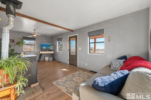 living room with beam ceiling, hardwood / wood-style flooring, and ceiling fan