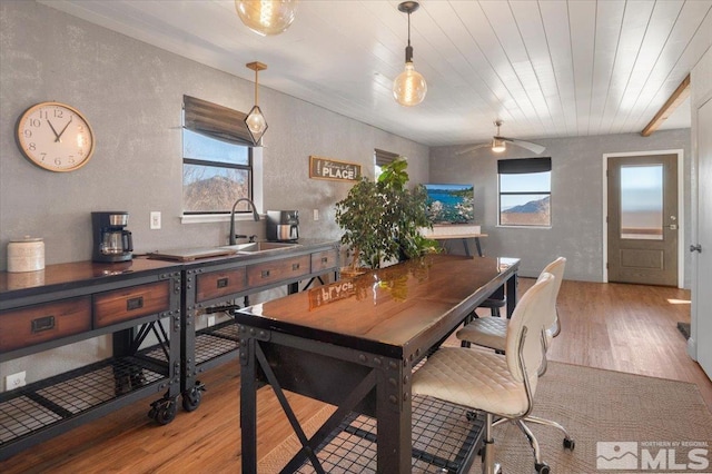 dining space featuring sink, wooden ceiling, and light wood-type flooring