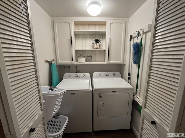 clothes washing area featuring cabinets and washer and clothes dryer