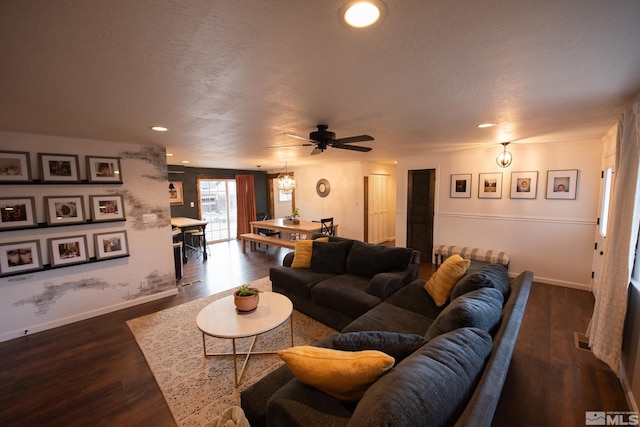 living room with dark wood-type flooring, ceiling fan, and a textured ceiling