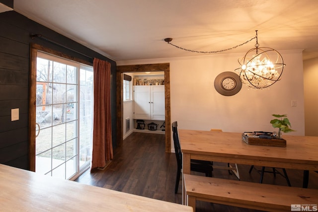 dining area featuring a notable chandelier, crown molding, and dark hardwood / wood-style floors