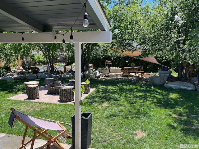 view of yard featuring a patio and an outdoor fire pit