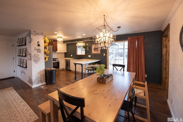 dining area with dark wood-type flooring, sink, and a notable chandelier