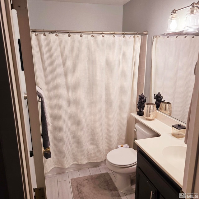 bathroom with vanity, curtained shower, tile patterned floors, and toilet