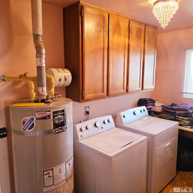 washroom featuring cabinets, washer and dryer, an inviting chandelier, and water heater