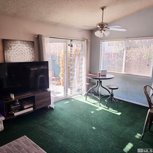 living room featuring ceiling fan, a textured ceiling, and dark colored carpet