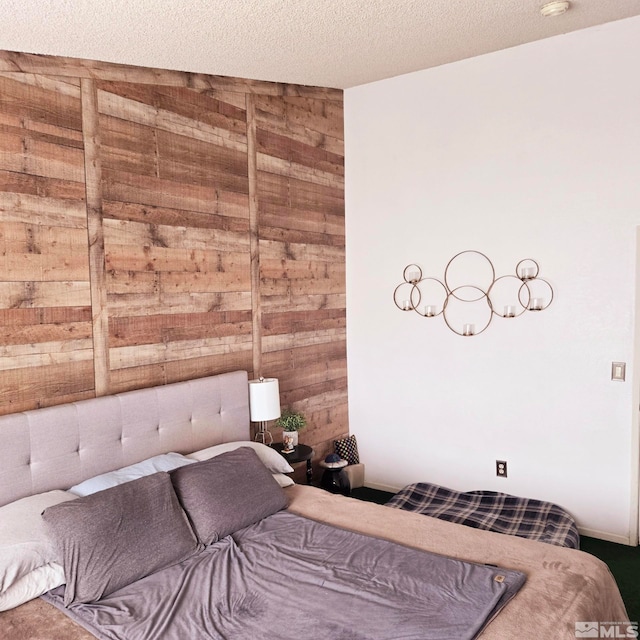 bedroom with a textured ceiling and wood walls