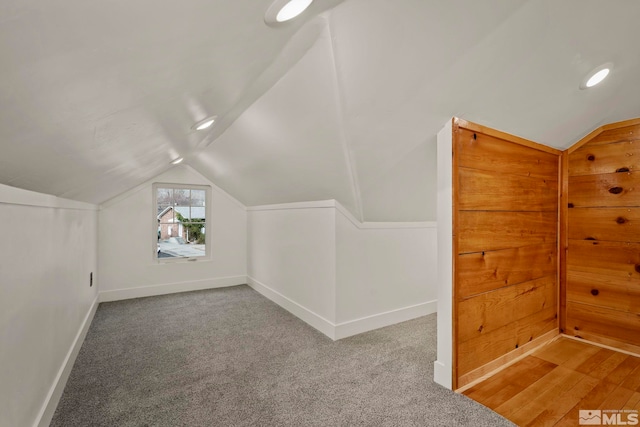 additional living space with vaulted ceiling and carpet flooring