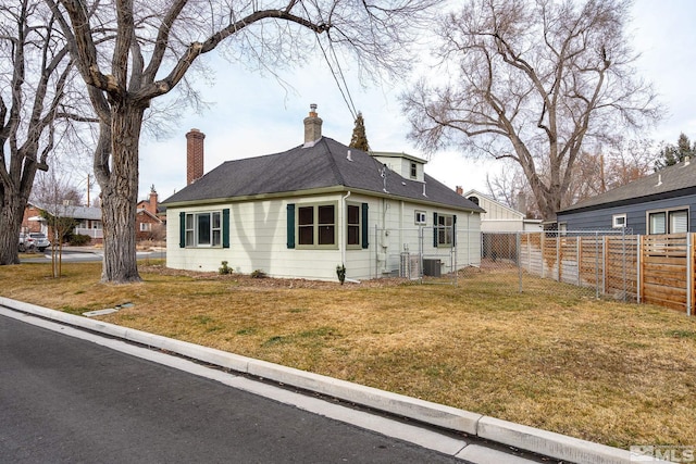 exterior space featuring central AC unit and a front lawn