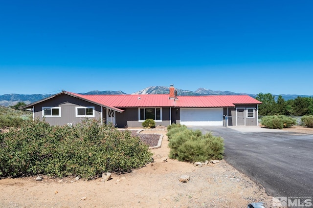 ranch-style home featuring a garage and a mountain view