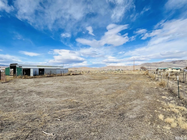 view of yard with a rural view and a mountain view