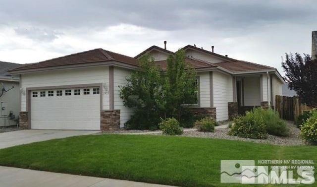 view of front of house featuring a garage, driveway, a front yard, and a tiled roof