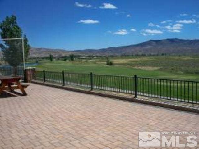 view of patio with fence and a mountain view