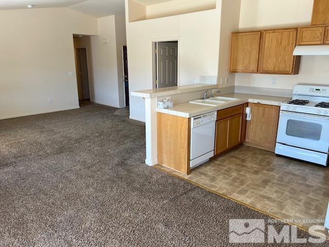 kitchen featuring high vaulted ceiling, sink, dark carpet, kitchen peninsula, and white appliances