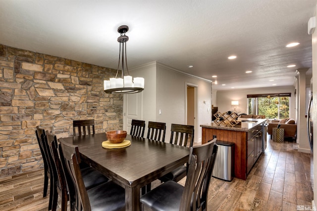 dining space with ornamental molding, sink, and light hardwood / wood-style floors