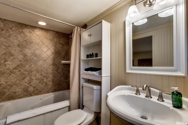 full bathroom with shower / tub combo with curtain, toilet, sink, and a textured ceiling