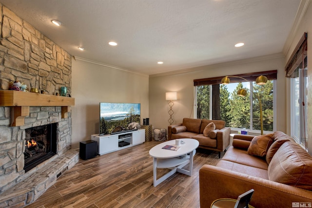 living room featuring ornamental molding, dark wood-type flooring, a textured ceiling, and a fireplace