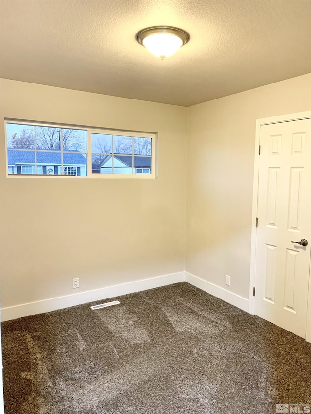 empty room featuring carpet floors and a textured ceiling