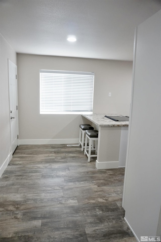 unfurnished dining area with dark wood-type flooring