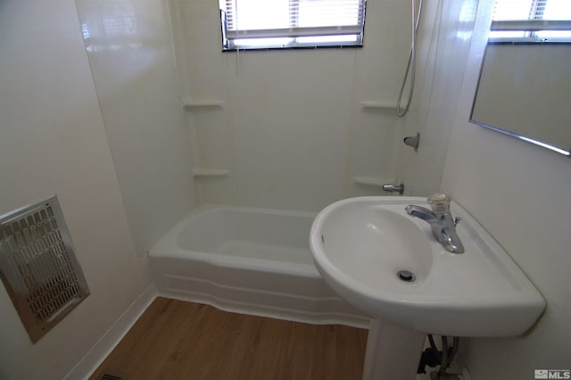 bathroom featuring wood-type flooring and shower / bathing tub combination