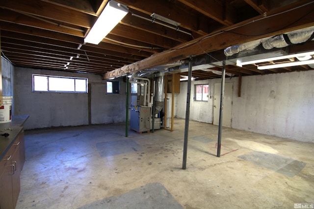 basement featuring a healthy amount of sunlight and heating unit