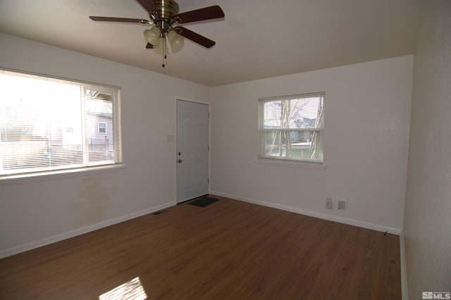 empty room with ceiling fan and dark hardwood / wood-style floors