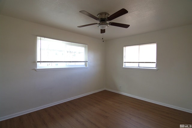 unfurnished room featuring dark wood-type flooring and ceiling fan