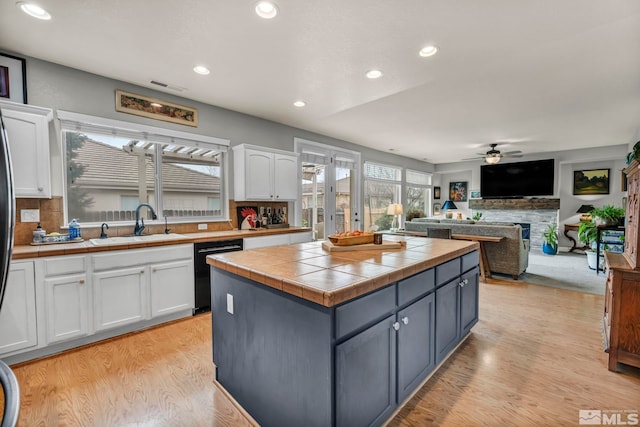 kitchen with white cabinetry, sink, dishwasher, and tile countertops