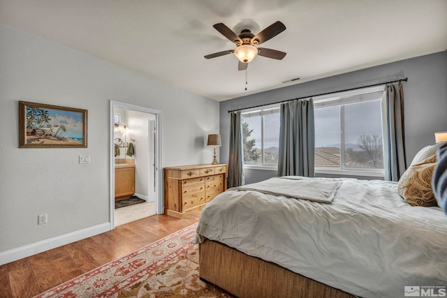 bedroom with ceiling fan, connected bathroom, and light hardwood / wood-style floors