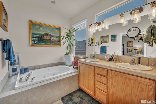 bathroom with tiled tub and vanity