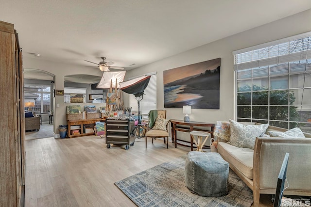 living area featuring light hardwood / wood-style floors and ceiling fan