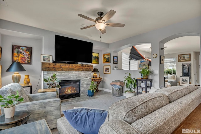 living room with a fireplace and ceiling fan