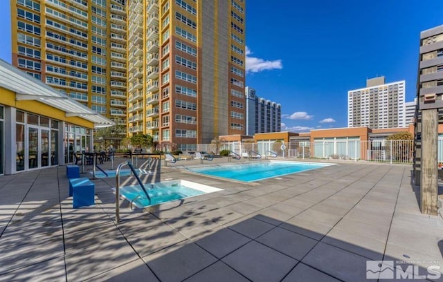 view of swimming pool featuring a community hot tub and a patio area