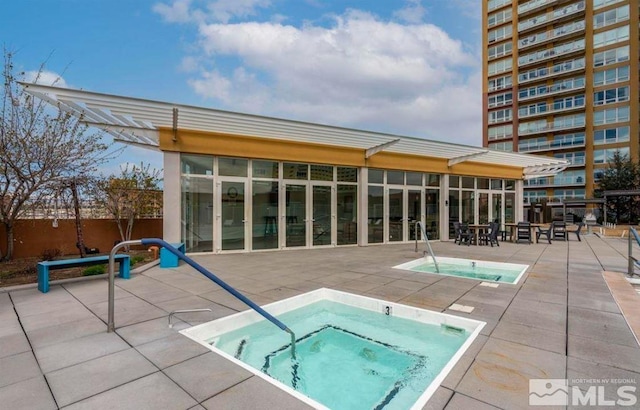 view of swimming pool with a patio area, a hot tub, and a sunroom