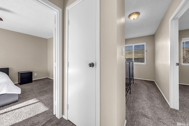 corridor featuring carpet flooring and a textured ceiling