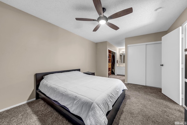 carpeted bedroom featuring ceiling fan, a textured ceiling, and ensuite bathroom