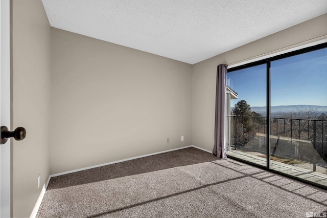 carpeted spare room featuring a mountain view and a textured ceiling