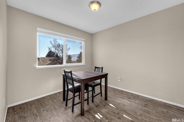 dining area with dark hardwood / wood-style floors and a textured ceiling