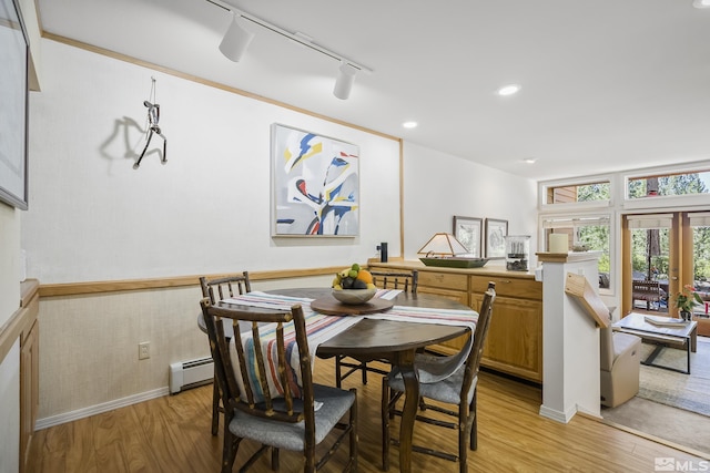 dining room with a baseboard radiator, rail lighting, light hardwood / wood-style floors, and french doors