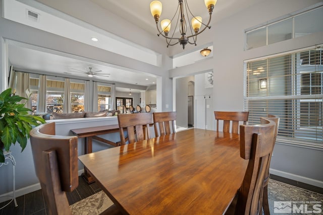 dining space with wood-type flooring and ceiling fan with notable chandelier