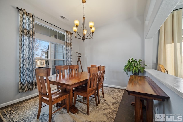 dining room with hardwood / wood-style flooring and a chandelier