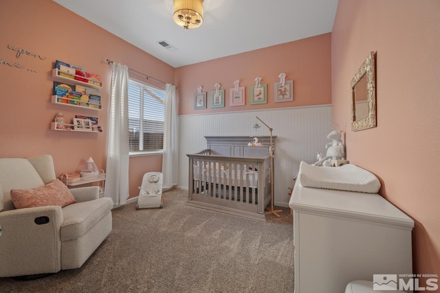 carpeted bedroom featuring a crib