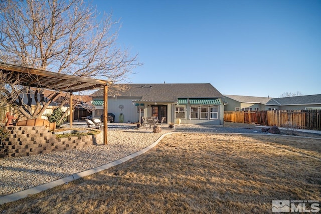 rear view of property featuring a pergola and a patio area