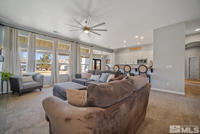 living room featuring light carpet and ceiling fan