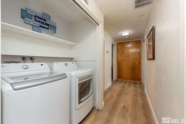 laundry room with light hardwood / wood-style floors and independent washer and dryer