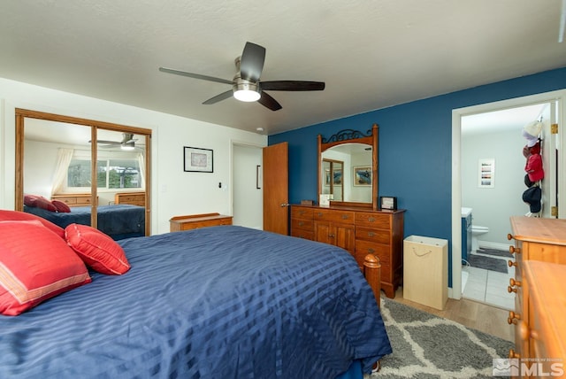 bedroom featuring hardwood / wood-style floors, ensuite bath, and ceiling fan