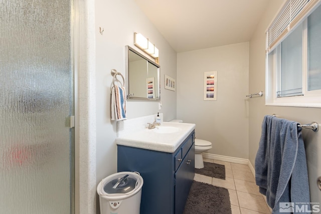 bathroom featuring vanity, a shower with door, tile patterned floors, and toilet